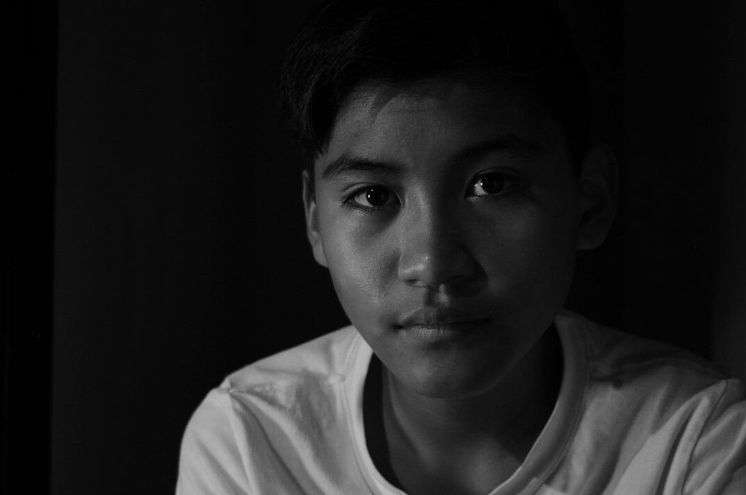 Portrait of a young man in a shirt looking at the camera